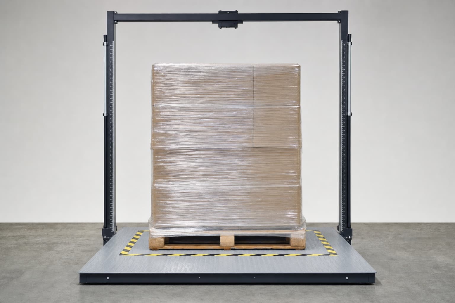 The same wrapped pallet standing on a floor scale platform with a dimensioning frame behind it